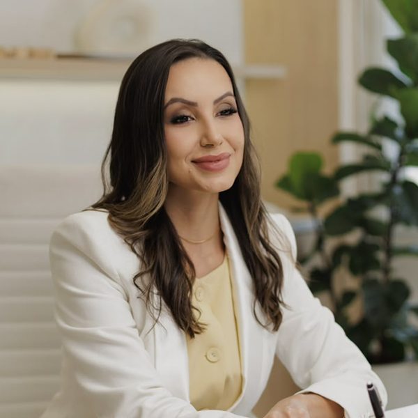 Dra. Amanda Rocha atendendo em seu consultório, anotando em uma agenda